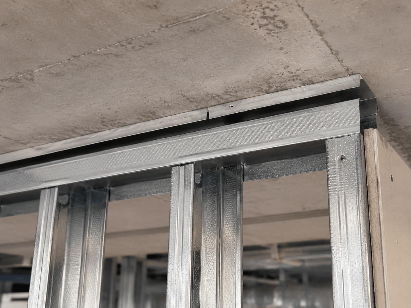 Commercial office fit-out under construction with newly installed internal partition walls and suspended ceiling grid within a modern office development.